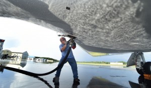 man standing under plane fueling it