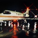 private jet parked on runway at night with lights on