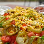 pile of nachos with jalapenos and shredded cheese
